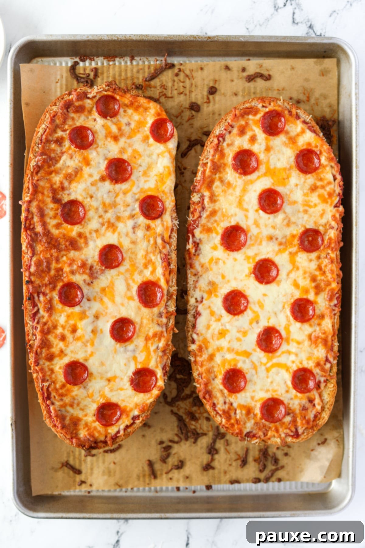 Speedy French Bread Pizzas 8 Two halves of French Bread pizza on a baking sheet.