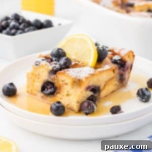 Overnight Brioche French Toast Bake 17 A square of baked French toast garnished with lemon and blueberries.