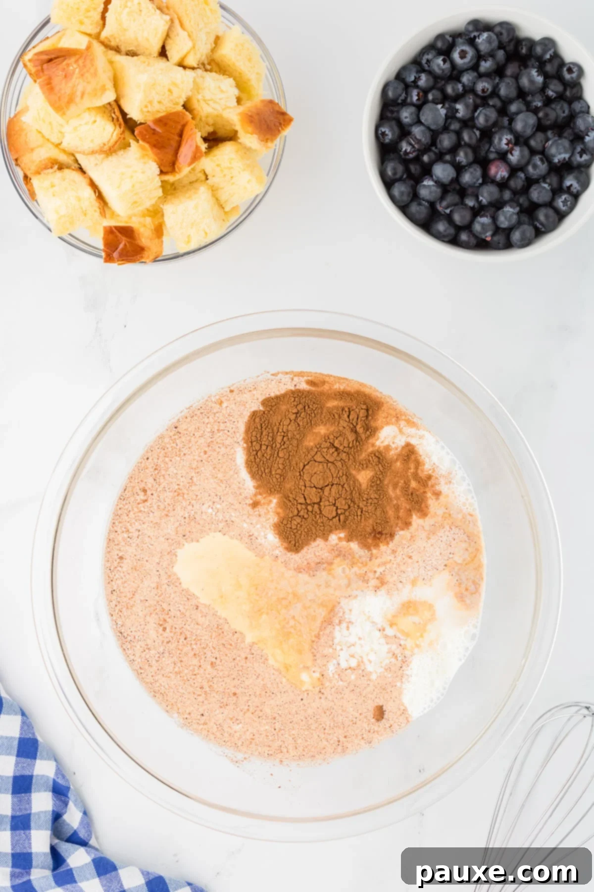 Overnight Brioche French Toast Bake 4 A large mixing bowl filled with ingredients for the French toast custard, including eggs, half and half, cinnamon, and brown sugar, ready to be whisked together.