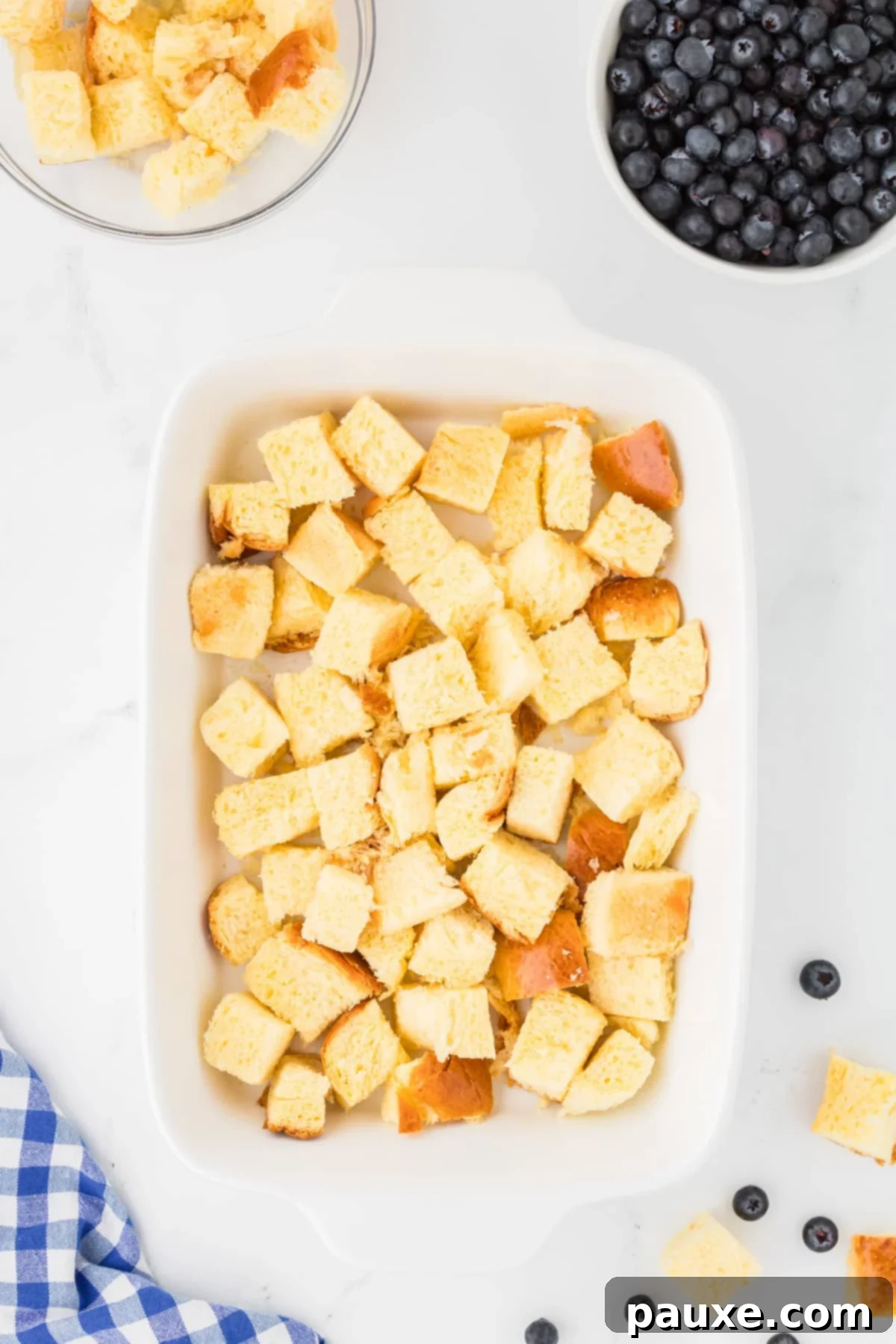 Overnight Brioche French Toast Bake 6 A 9x13 inch baking dish generously filled with cubed brioche bread, forming an even base layer for the French toast casserole.