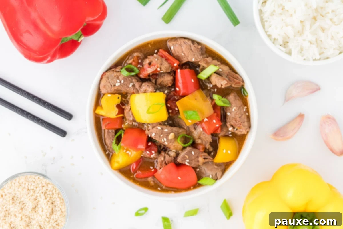 Easy Slow Cooker Pepper Steak 13 An overhead view of a bowl of steak strips with peppers and sauce, ready to be served.