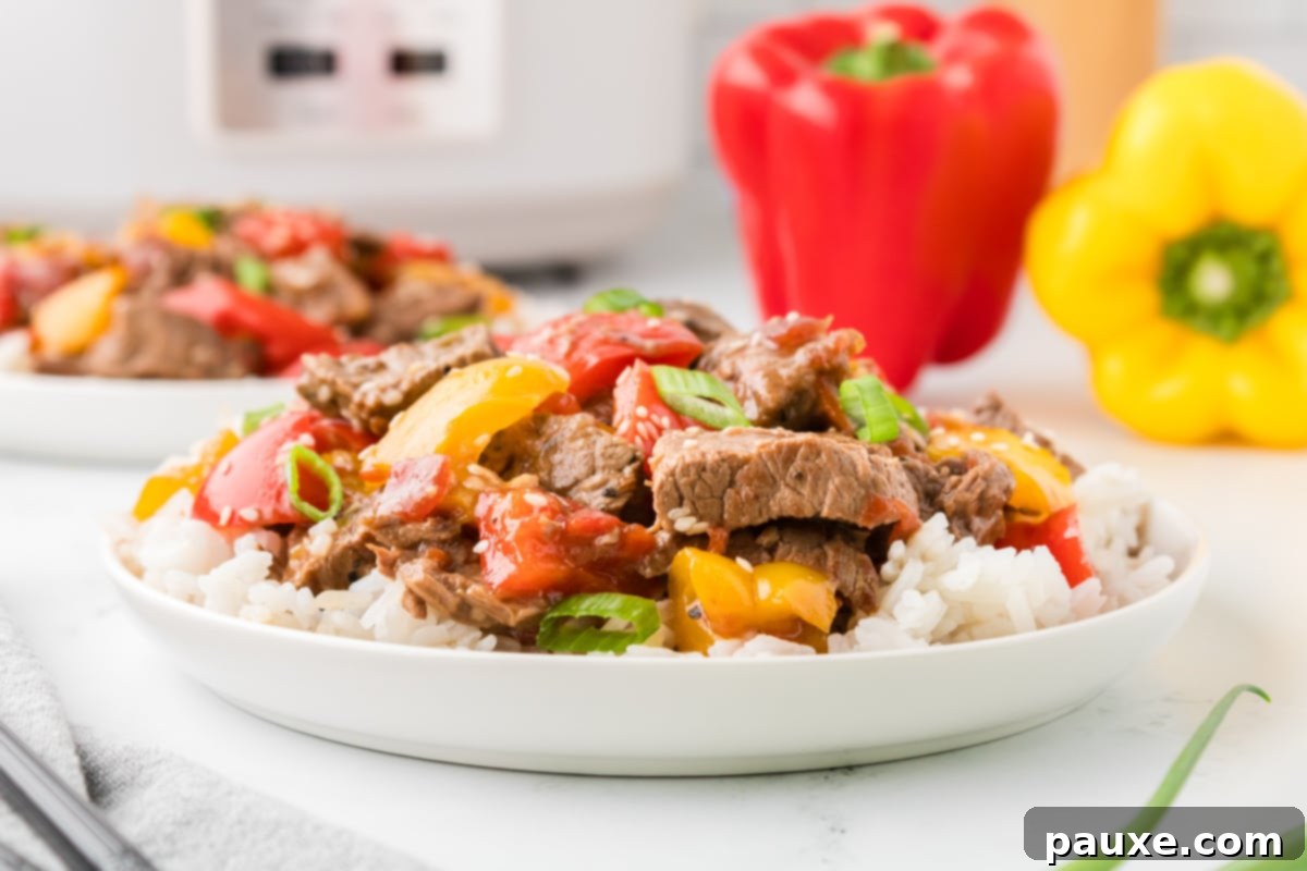 Easy Slow Cooker Pepper Steak 15 A bowl with tender peppers and beef strips in a rich sauce.