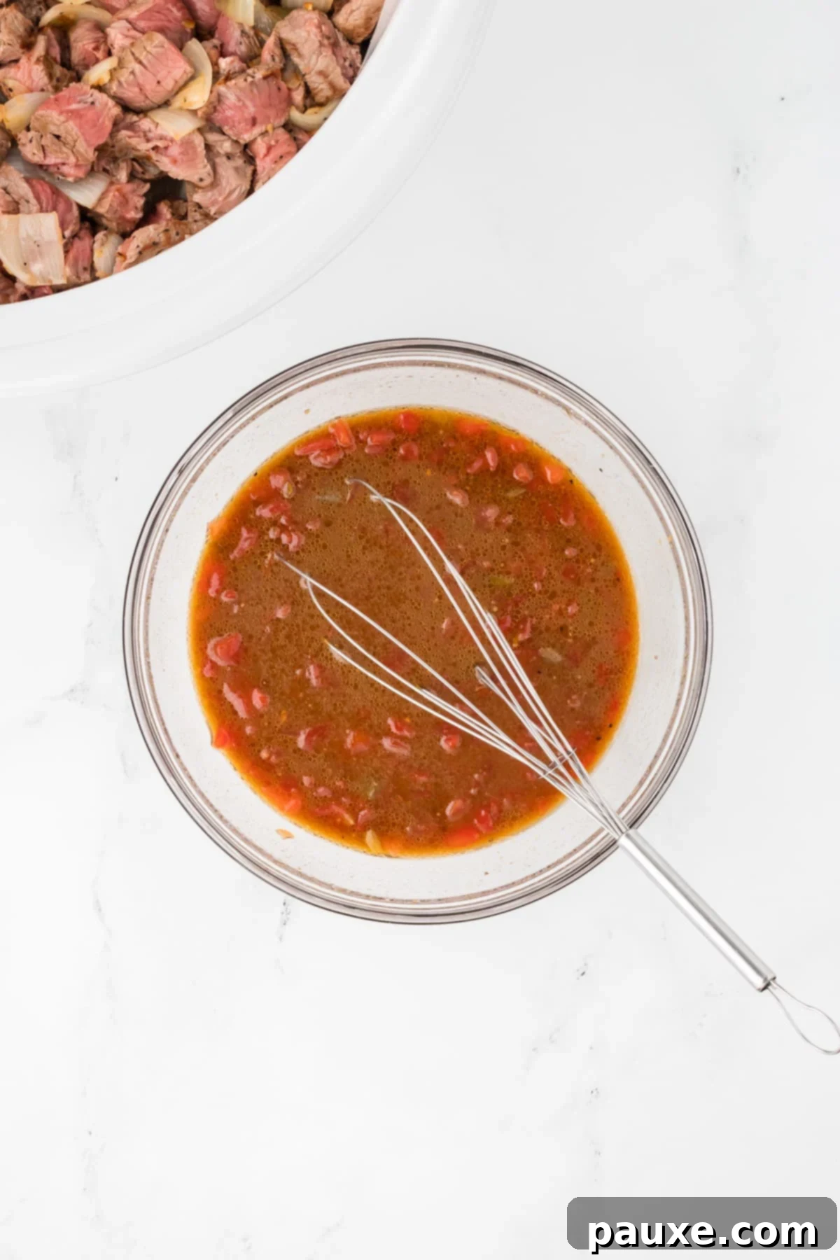 Easy Slow Cooker Pepper Steak 8 A small bowl with a whisk, showing the sauce ingredients being combined.