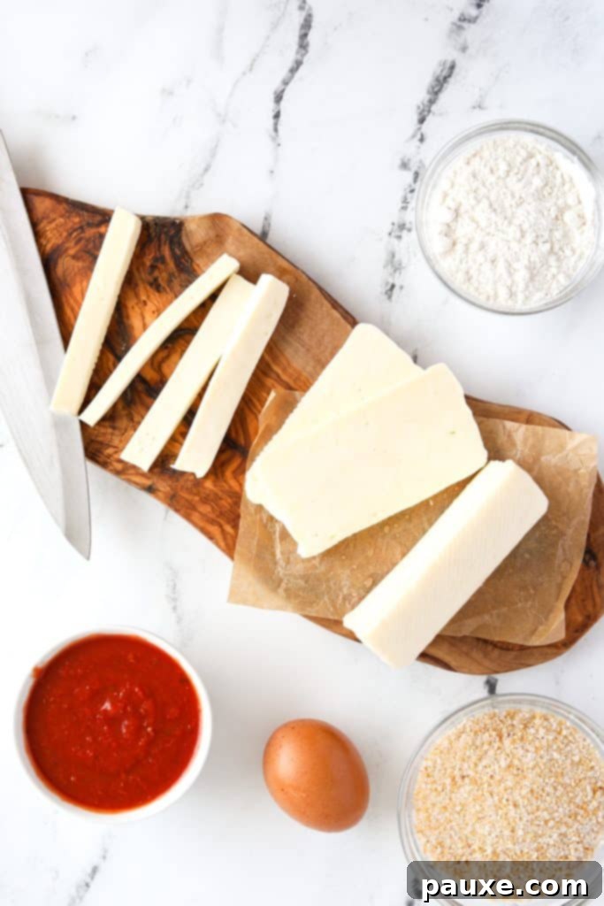 Crispy Air Fryer Halloumi Fries 4 A cutting board with a block of halloumi cheese meticulously cut into uniform french fry-like sticks.