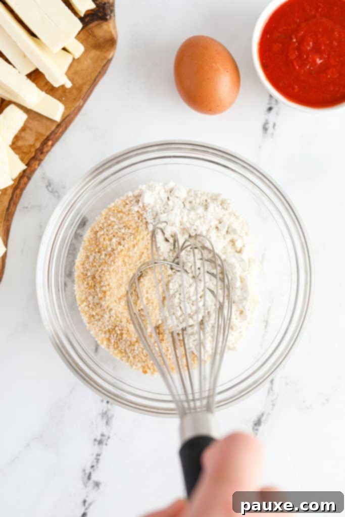 Crispy Air Fryer Halloumi Fries 5 A medium-sized bowl containing all-purpose flour and panko breadcrumbs, being whisked together until thoroughly combined.