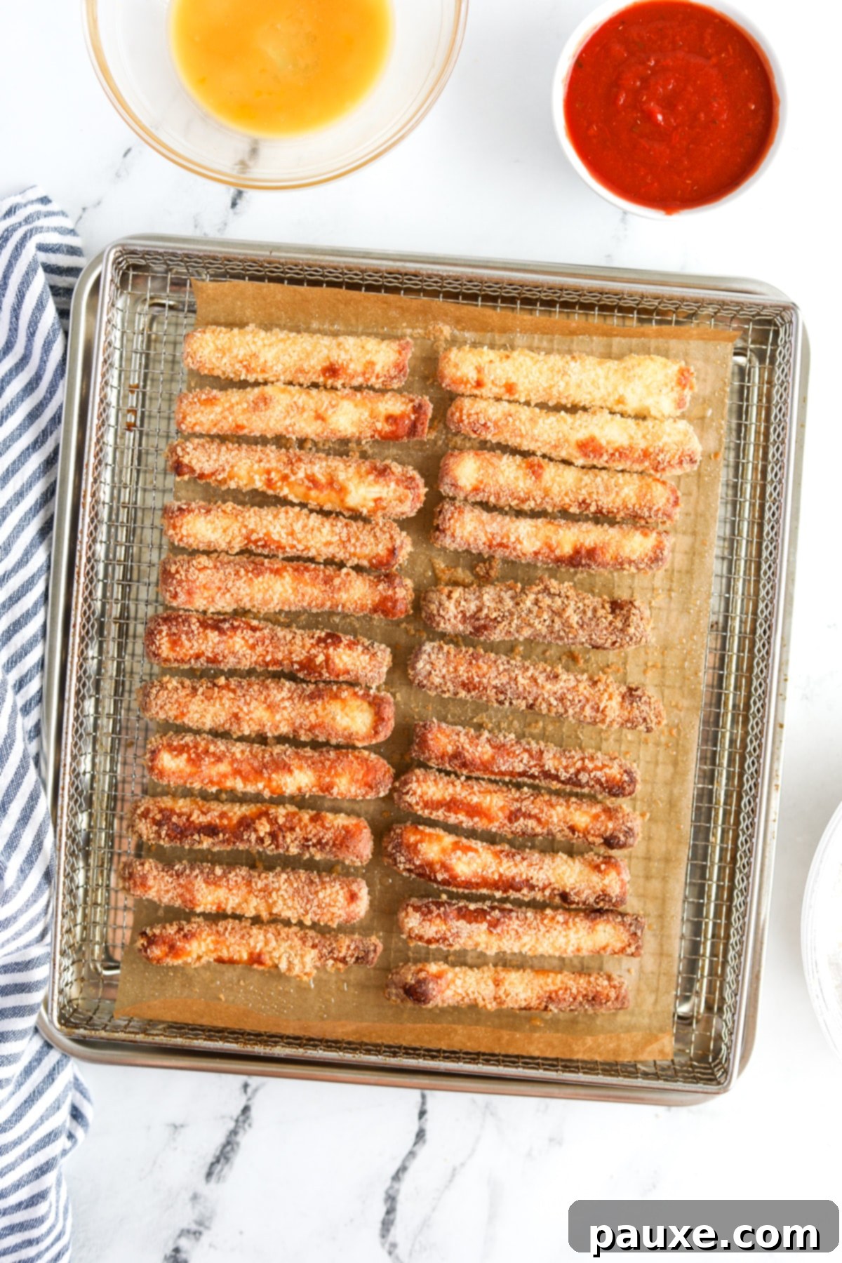 Crispy Air Fryer Halloumi Fries 9 An air fryer tray filled with perfectly golden brown and crispy halloumi fries, fresh out of the air fryer.