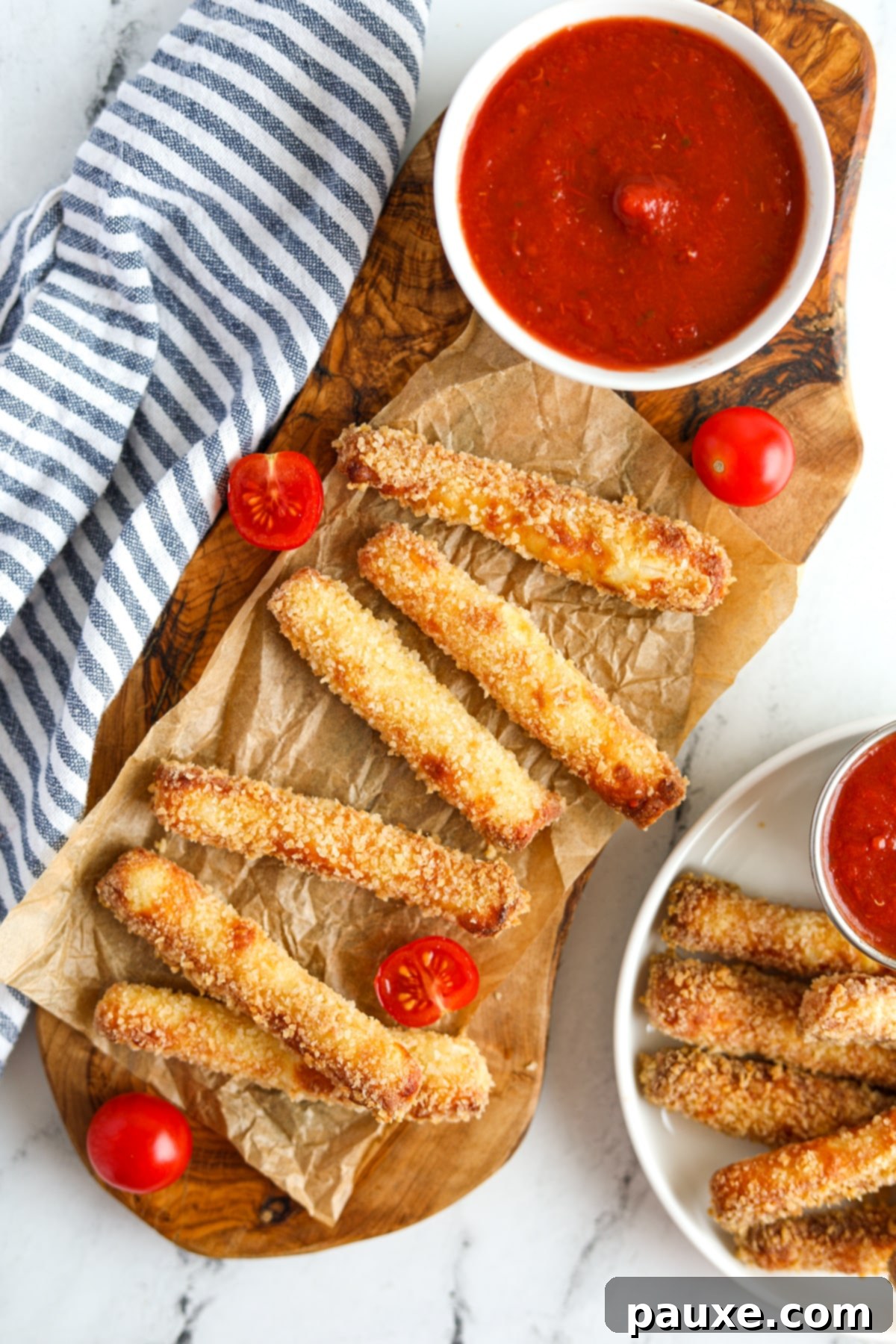 Crispy Air Fryer Halloumi Fries 10 A rustic wooden platter generously filled with an abundance of golden, crispy air fryer halloumi fries, accompanied by a small bowl of savory pizza sauce for dipping.