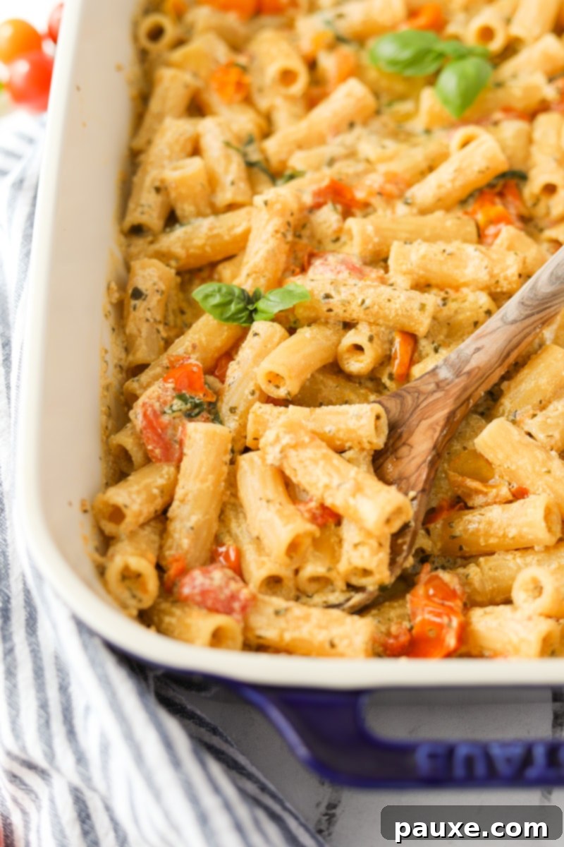 Creamy Boursin Pasta Bake 14 A spoon scooping a generous portion of creamy Boursin pasta from a serving dish, highlighting the rich sauce.