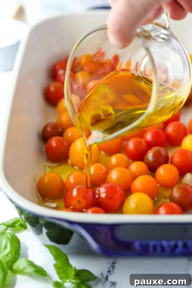 Creamy Boursin Pasta Bake 5 Drizzling extra virgin olive oil generously over the cherry tomatoes in a baking dish.