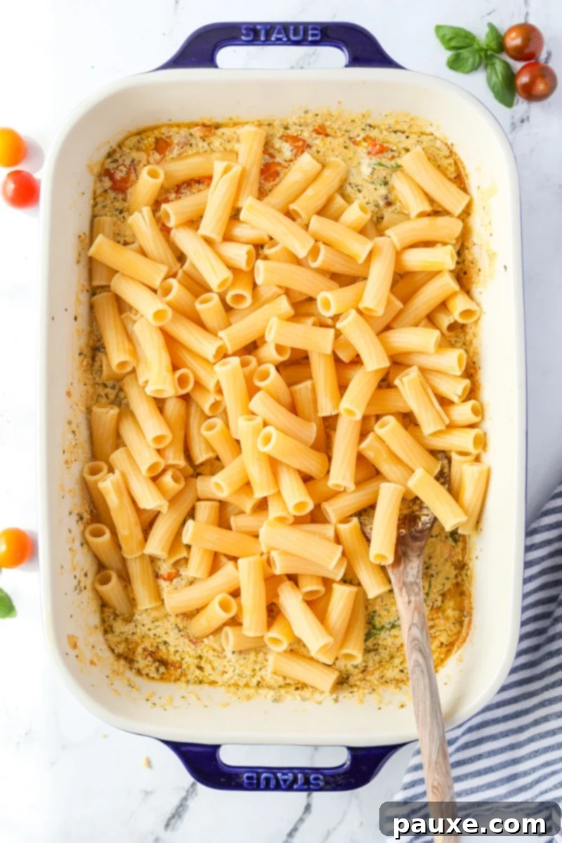 Creamy Boursin Pasta Bake 9 The baking dish now contains the creamy Boursin sauce mixed with cooked pasta.