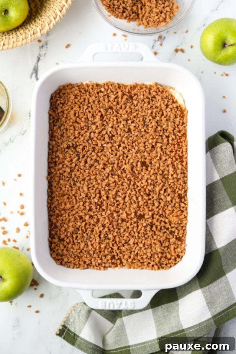 Irresistible Caramel Apple Delight 9 A finished, enticing caramel dip beautifully covered with a generous, even layer of glistening toffee bits, inviting immediate indulgence.