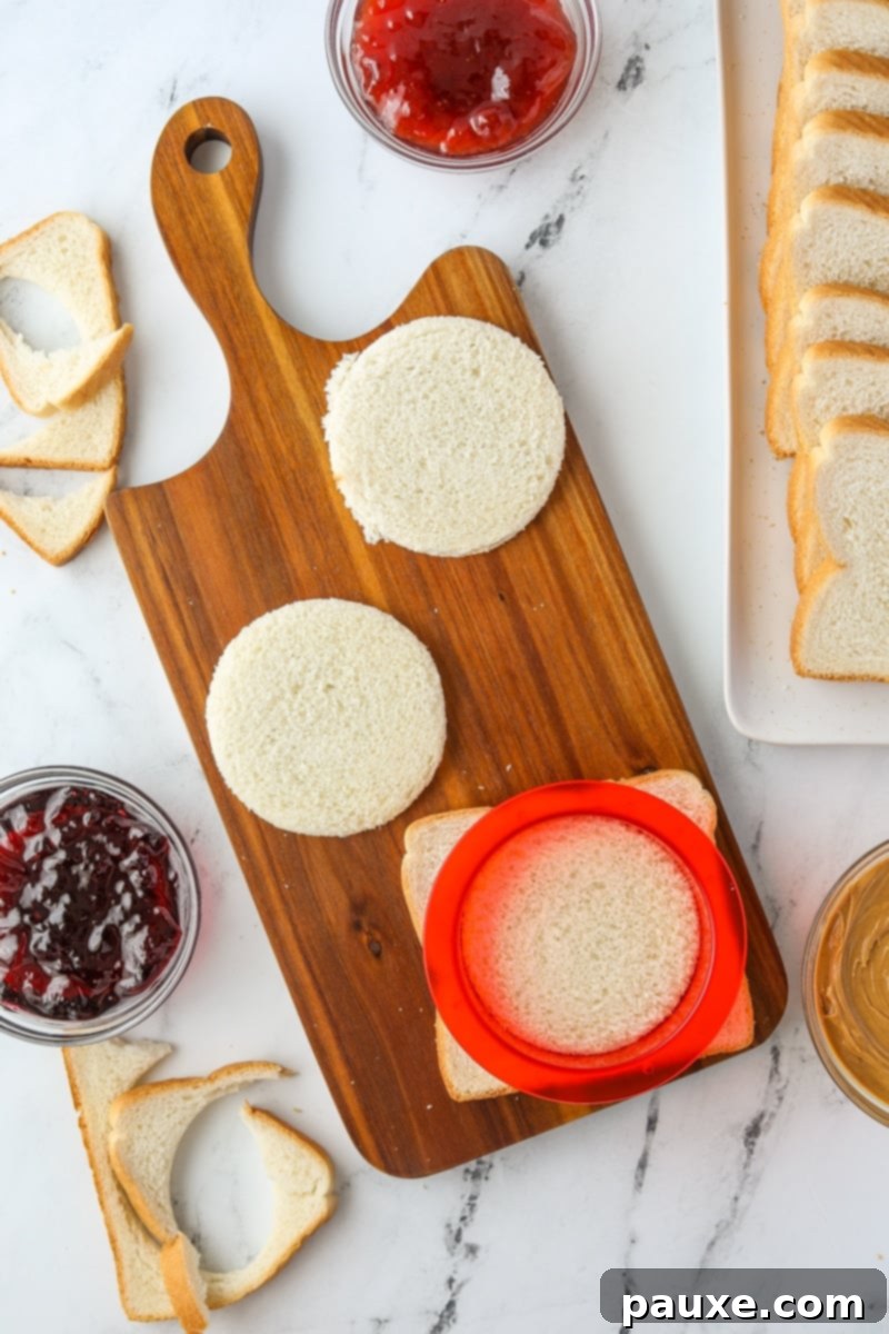 DIY Crustless Sandwich Pockets 4 Using a round sandwich cutter to press down and cut a slice of bread into a perfect circle, removing the crust.