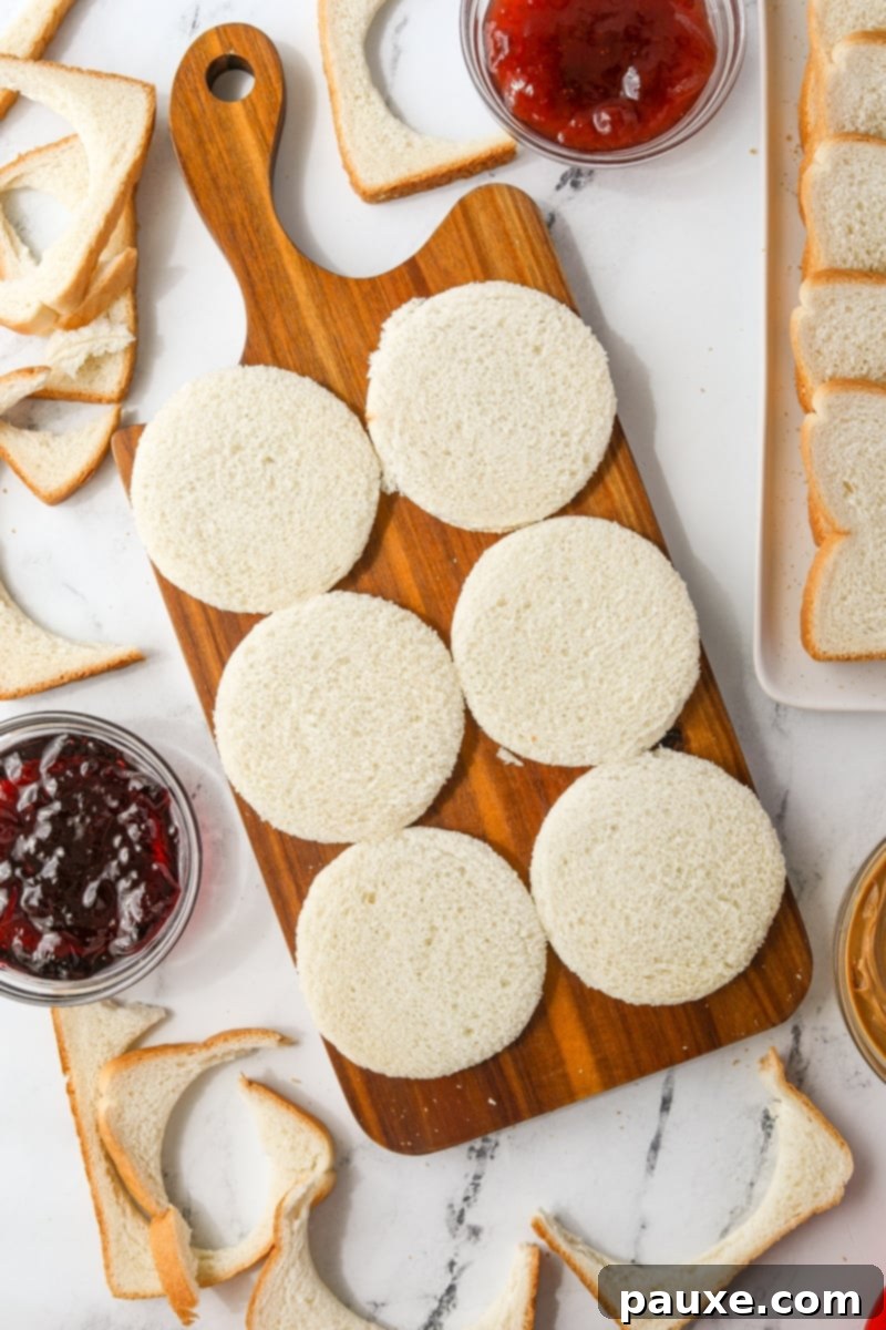 DIY Crustless Sandwich Pockets 5 A cutting board neatly displaying six perfectly cut circular bread rounds, ready for filling.