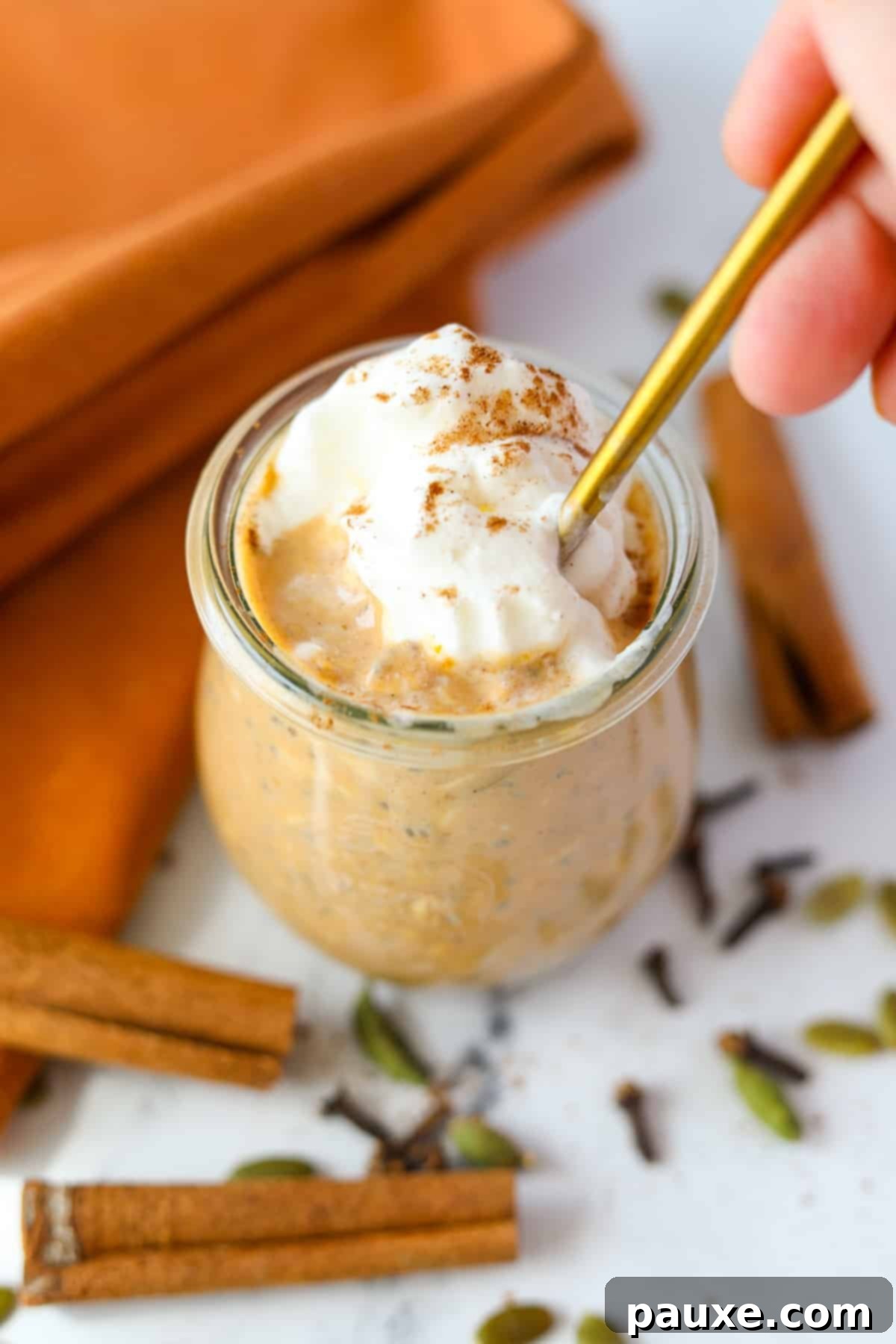 Pumpkin Spice Overnight Oats 2 A spoon taking a portion from a jar of pumpkin overnight oatmeal.