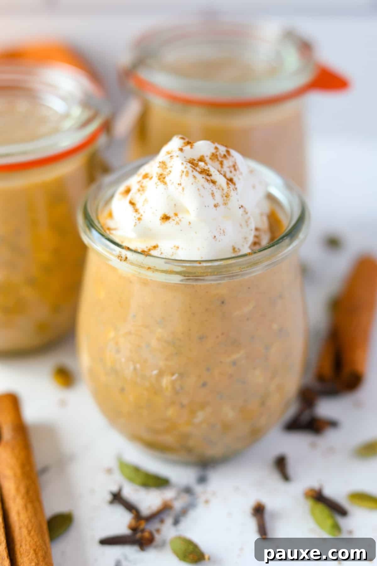 Pumpkin Spice Overnight Oats 13 A jar of overnight oats, garnished with whipped cream and a pinch of pumpkin spice on top.