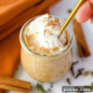 Pumpkin Spice Overnight Oats 14 A small jar of pumpkin overnight oatmeal with whipped cream on top, ready to eat.