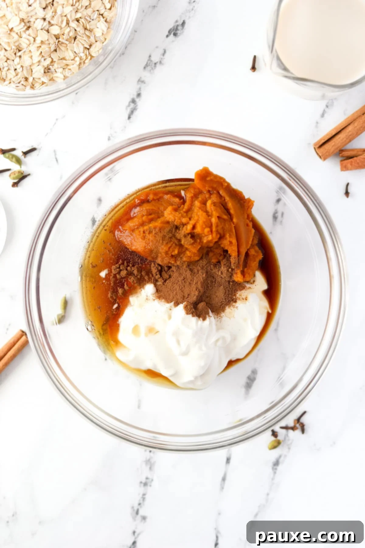 Pumpkin Spice Overnight Oats 4 A bowl filled with greek yogurt, pumpkin, maple syrup, and spices.