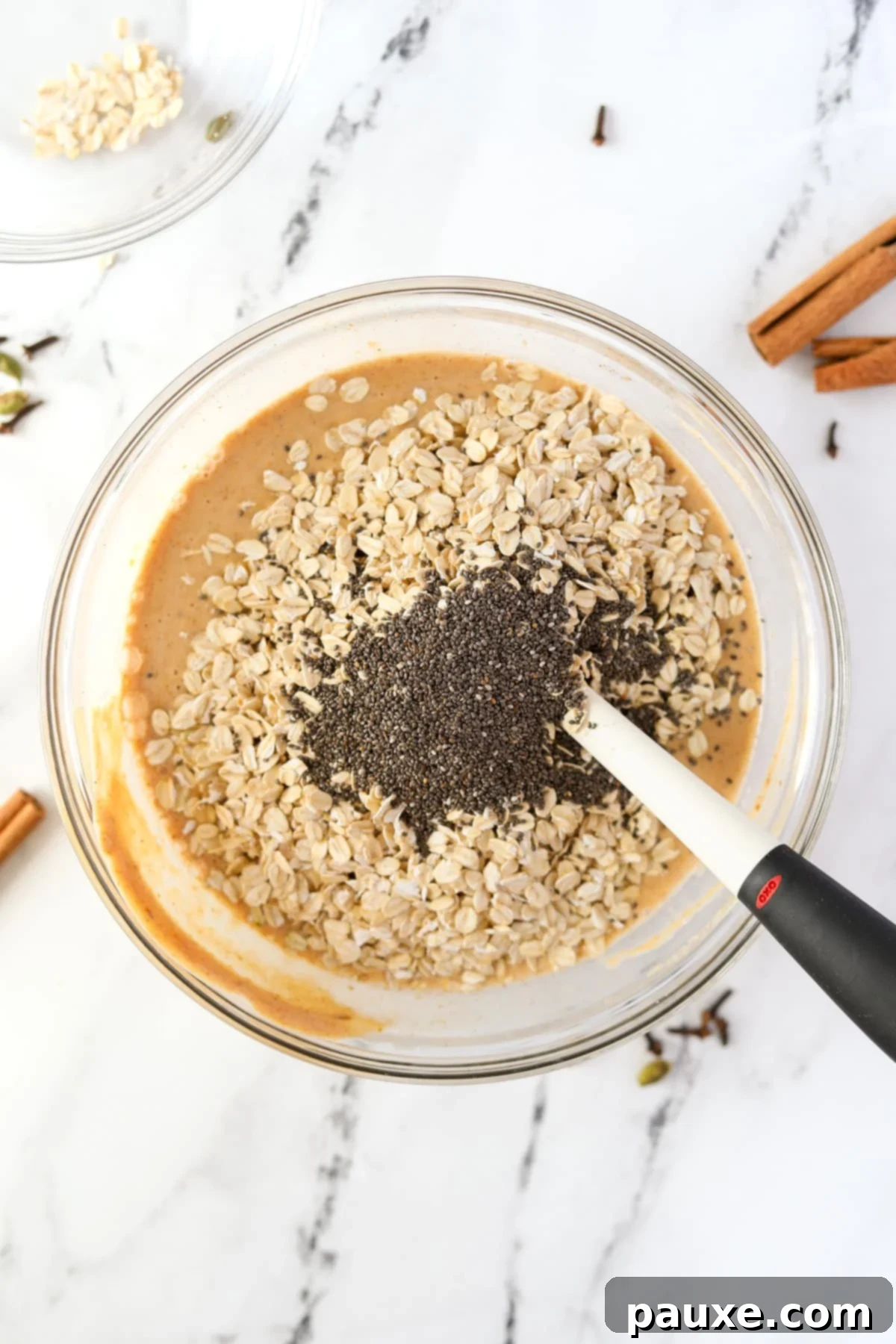 Pumpkin Spice Overnight Oats 7 Adding oats and chia seeds to a bowl of pumpkin colored liquid.