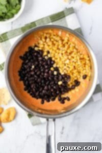 Zesty Fiesta Dip 19 Adding beans and corn to melted Rotel dip.