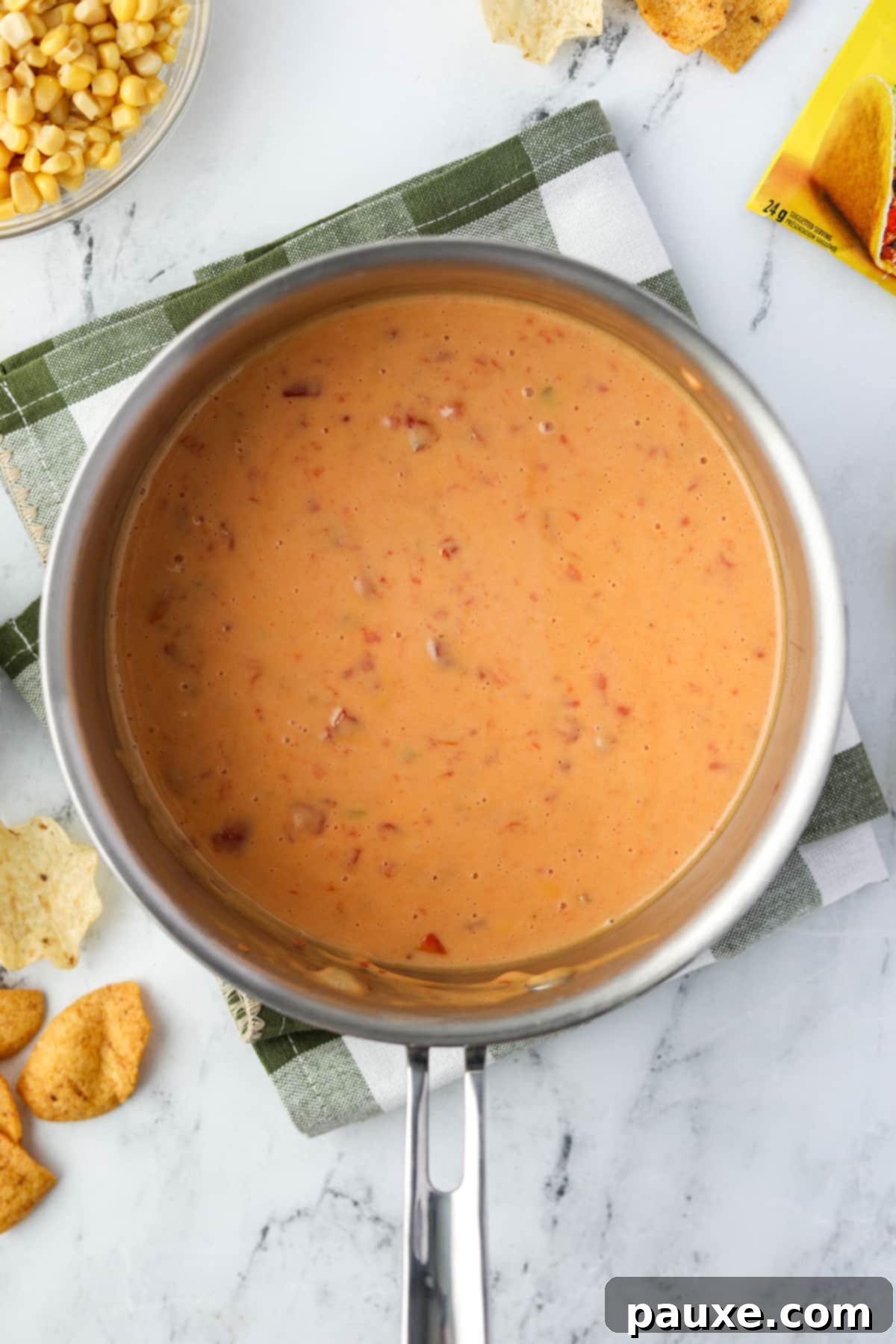 Zesty Fiesta Dip 5 A saucepan filled with melted Velveeta cheese and Rotel dip, stirred until smooth and creamy.