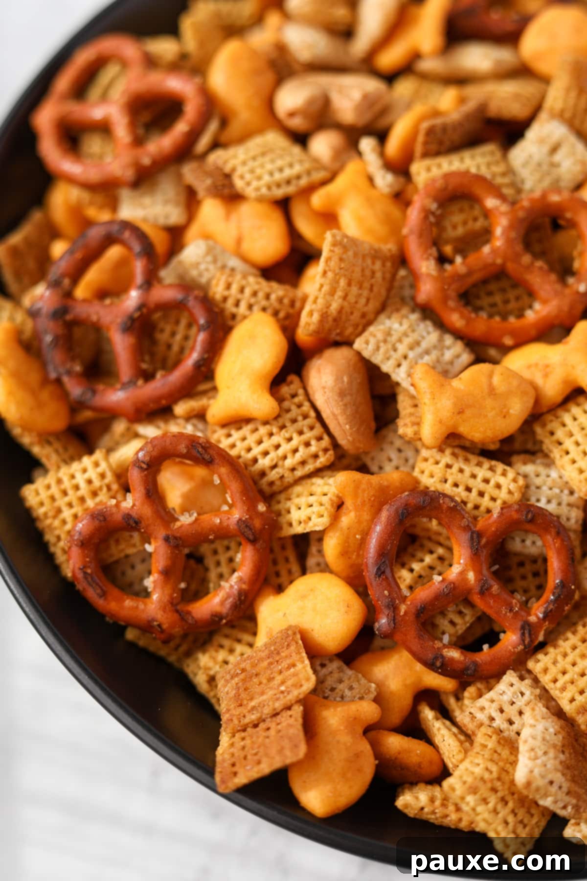 Savory Goldfish Crunch Mix 12 A close up of chex mix with Goldfish crackers.