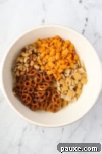 Savory Goldfish Crunch Mix 16 A large bowl containing pretzels, goldfish crackers, nuts, and cereal.
