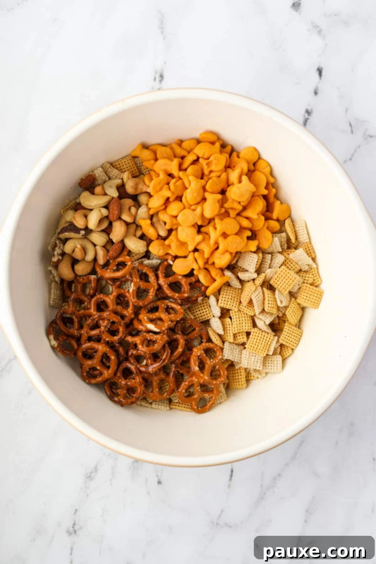 Savory Goldfish Crunch Mix 4 A large bowl containing pretzels, goldfish crackers, nuts, and cereal.