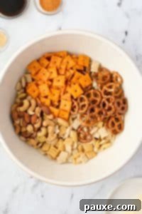 Savory Snack Medley 15 A bowl with cheese crackers, Chex mix, pretzels, and mixed nuts, ready for seasoning.