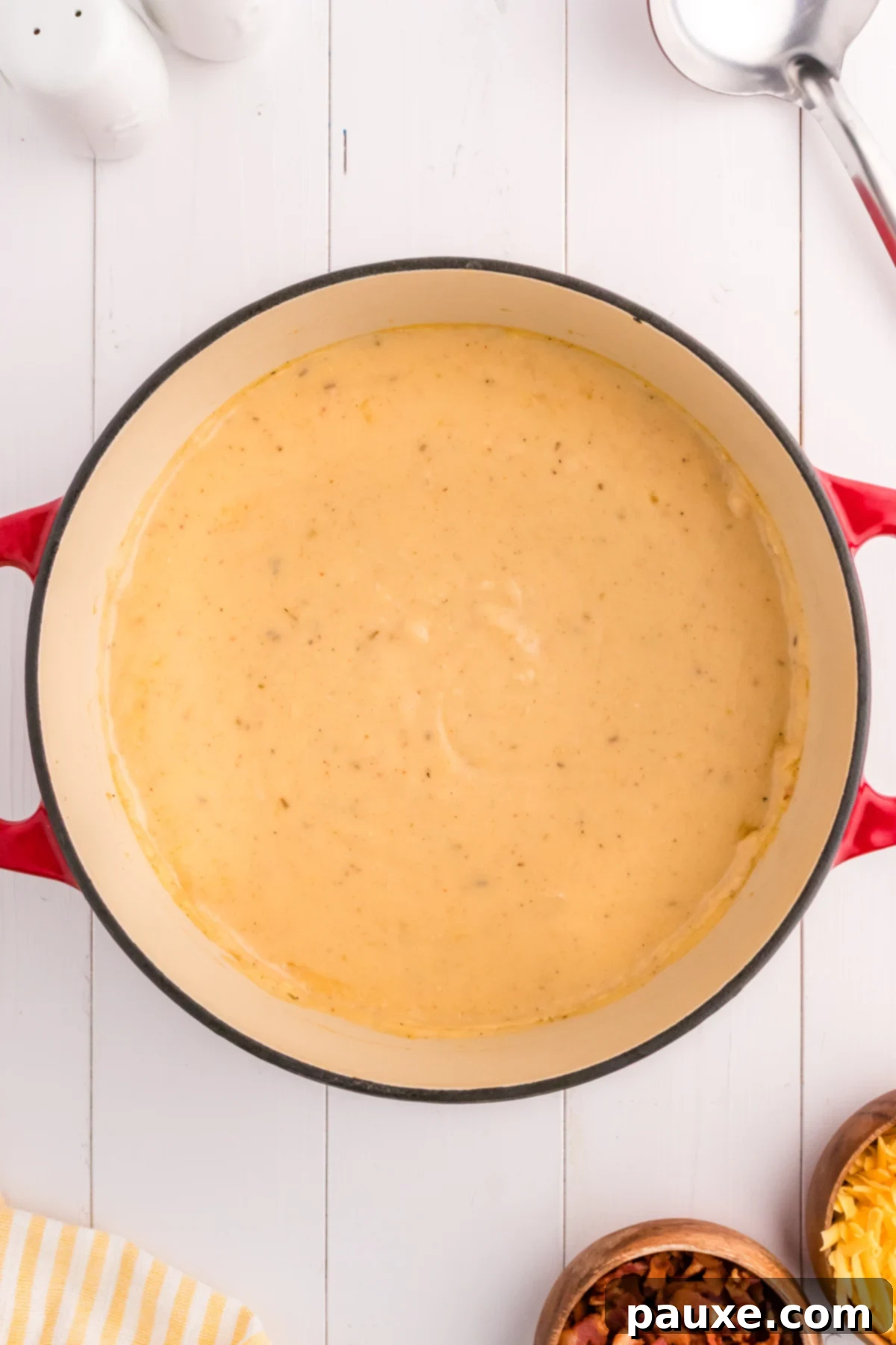 The finished creamy potato soup being stirred in a Dutch oven, ready for serving.
