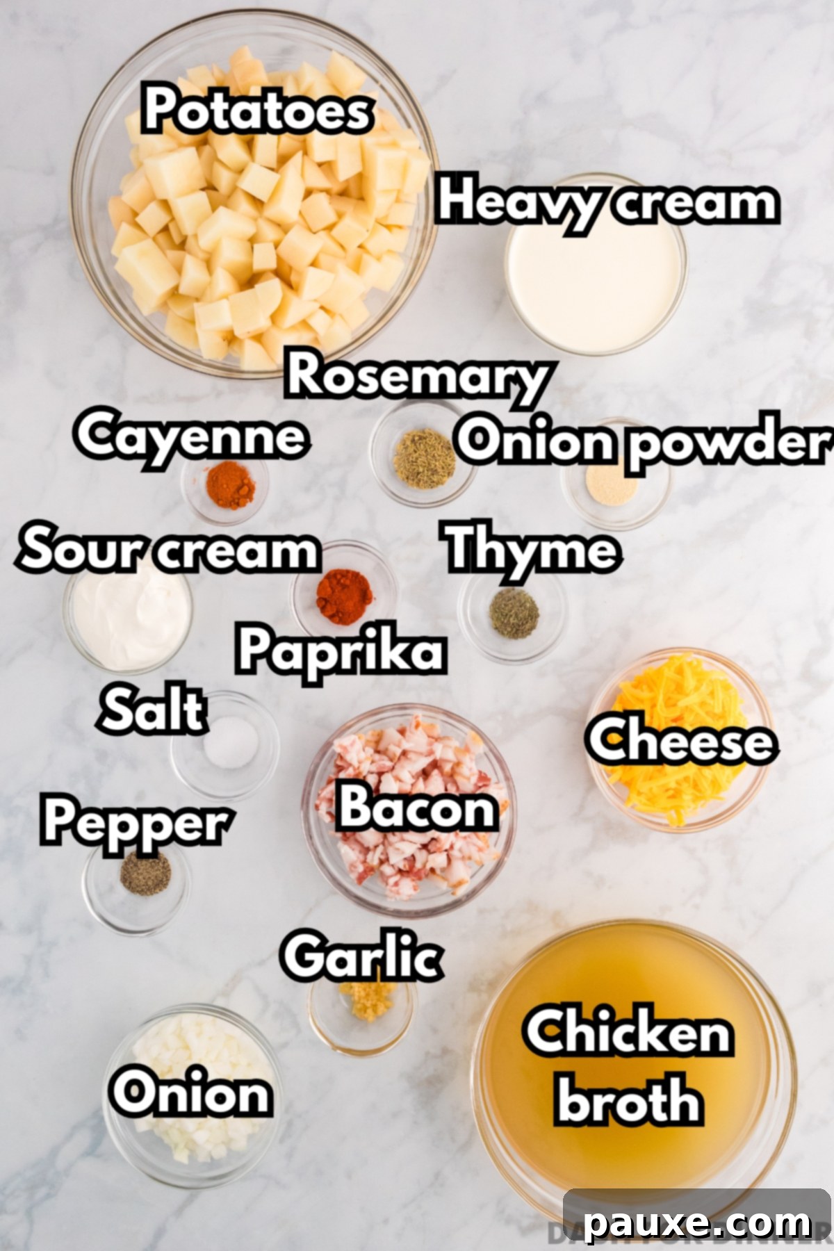 A selection of fresh ingredients including russet potatoes, bacon, onions, garlic, and spices, laid out on a wooden board.