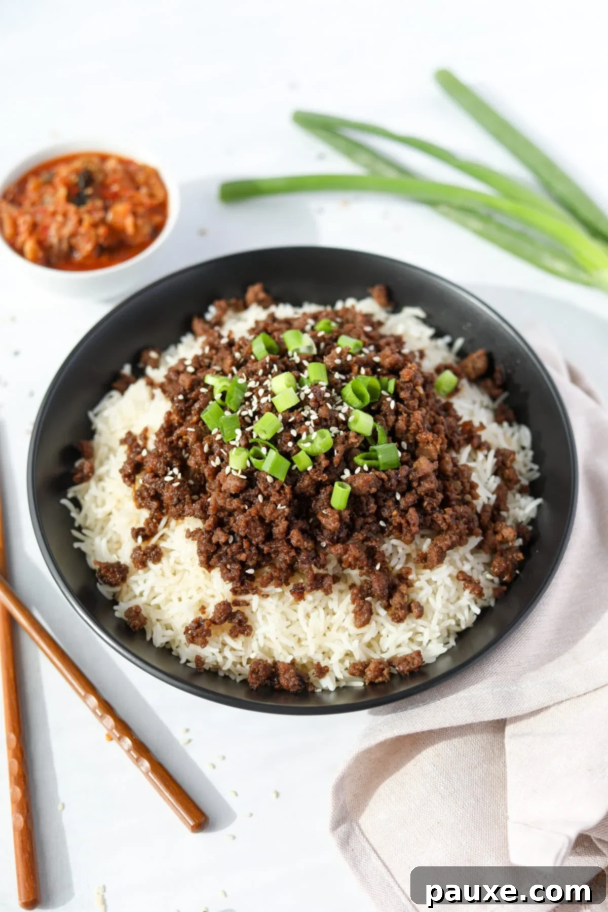 Authentic Korean Marinated Beef 2 A bowl of rice topped with seasoned ground beef, green onions, and sesame seeds. A perfect weeknight meal.