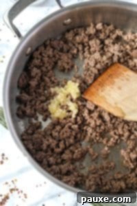 Authentic Korean Marinated Beef 16 Adding garlic to a skillet with ground beef.