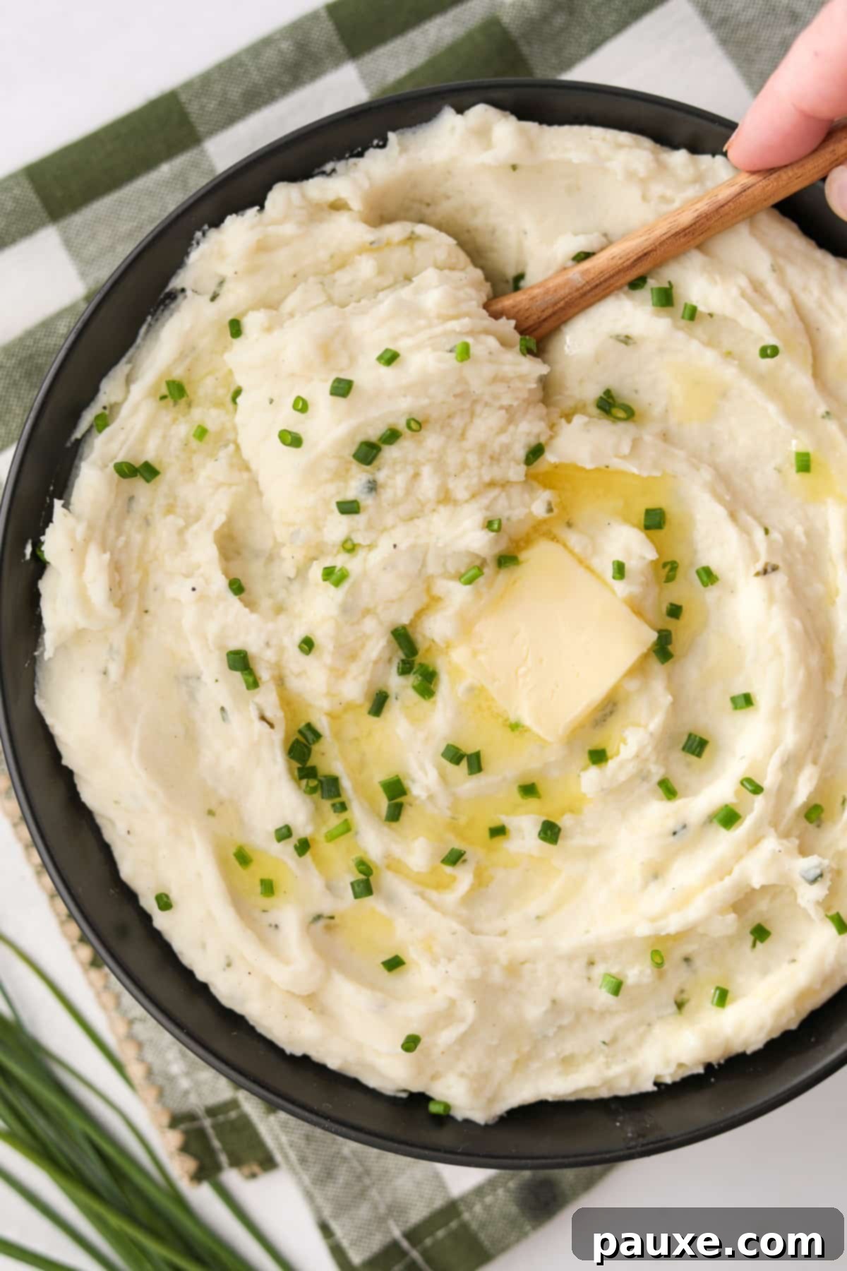 Creamy Garlic Herb Boursin Mash 12 A bowl of mashed potatoes topped with chopped chives.