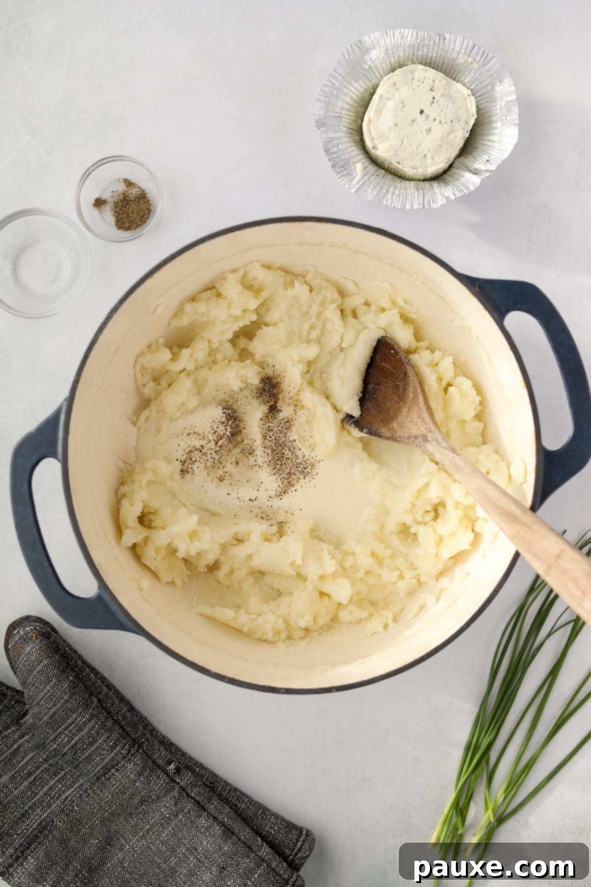 Creamy Garlic Herb Boursin Mash 7 A dutch oven with mashed potatoes with cream, salt, and pepper.