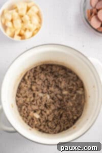 Rancher's Hearty Stew 18 Ground beef being cooked and broken up in a large soup pot.