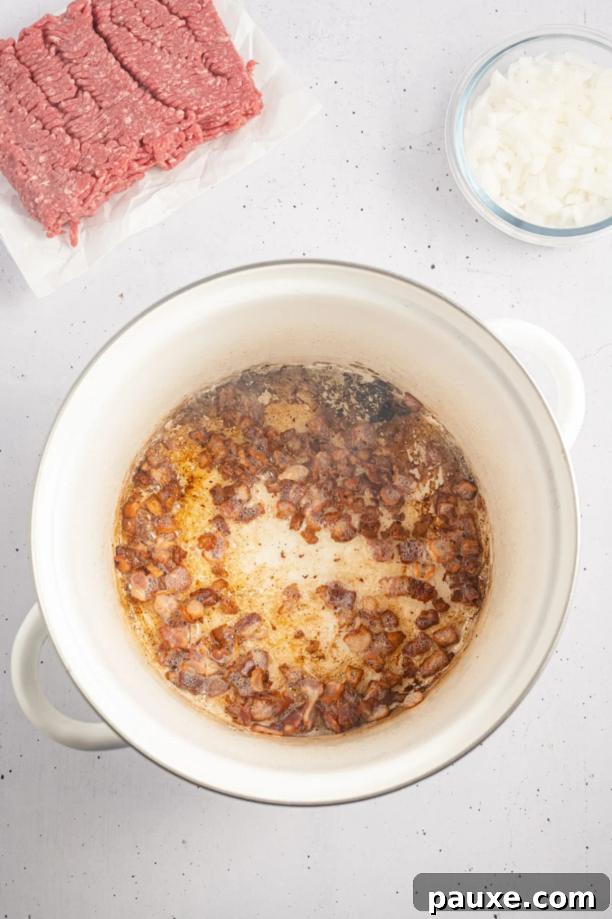 Rancher's Hearty Stew 4 A large pot on the stovetop with diced white onions sizzling and softening in rich bacon fat, preparing the aromatic base for the stew.