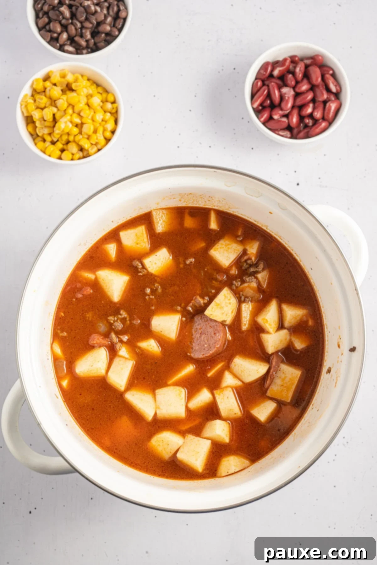 Rancher's Hearty Stew 7 A hearty soup pot filled with a rich, savory beef broth and tender cubed potatoes, simmering gently to absorb the deep flavors.