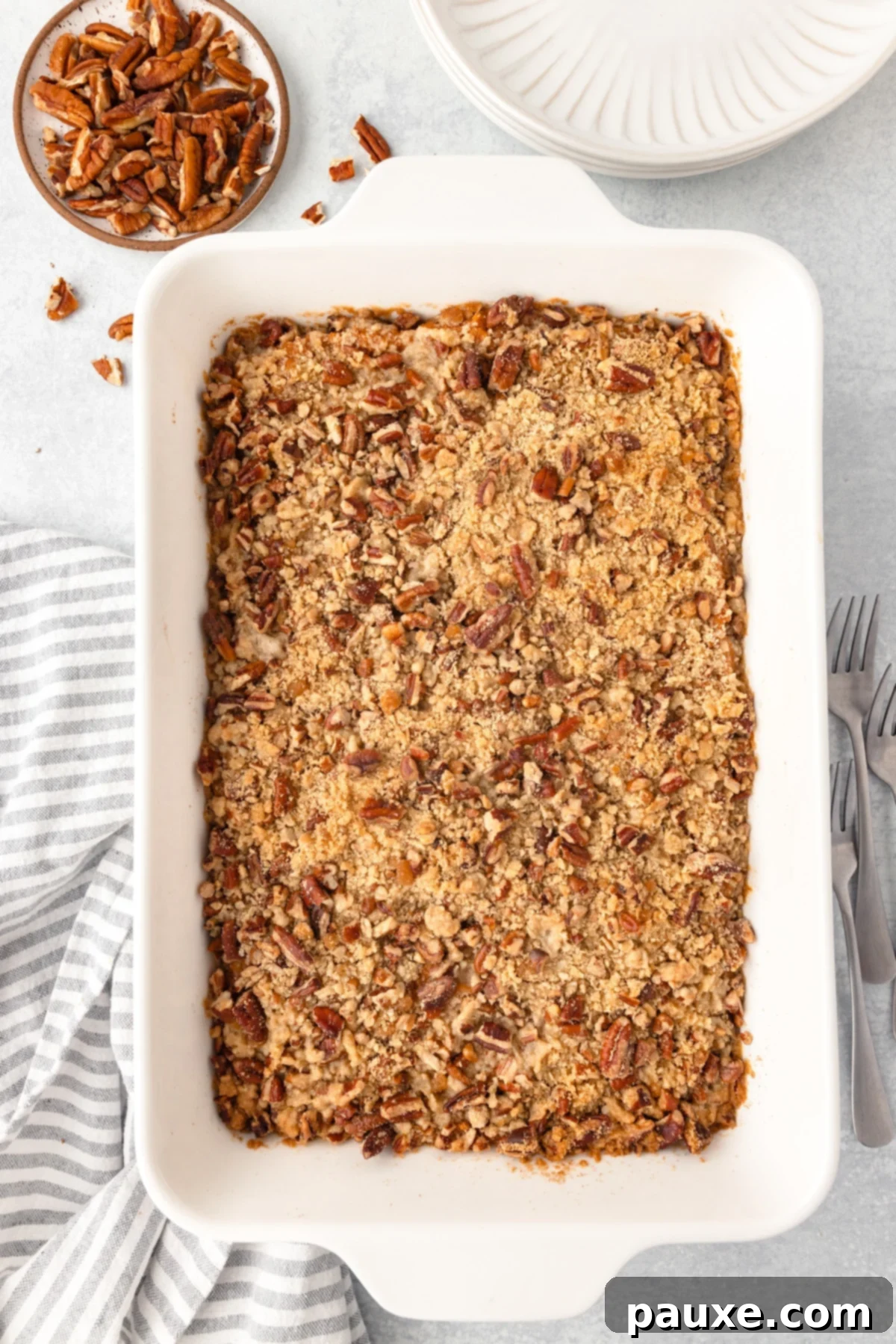 Pecan Streusel Sweet Potato Bake 11 Sweet potato casserole in a large white baking dish, topped with pecans.