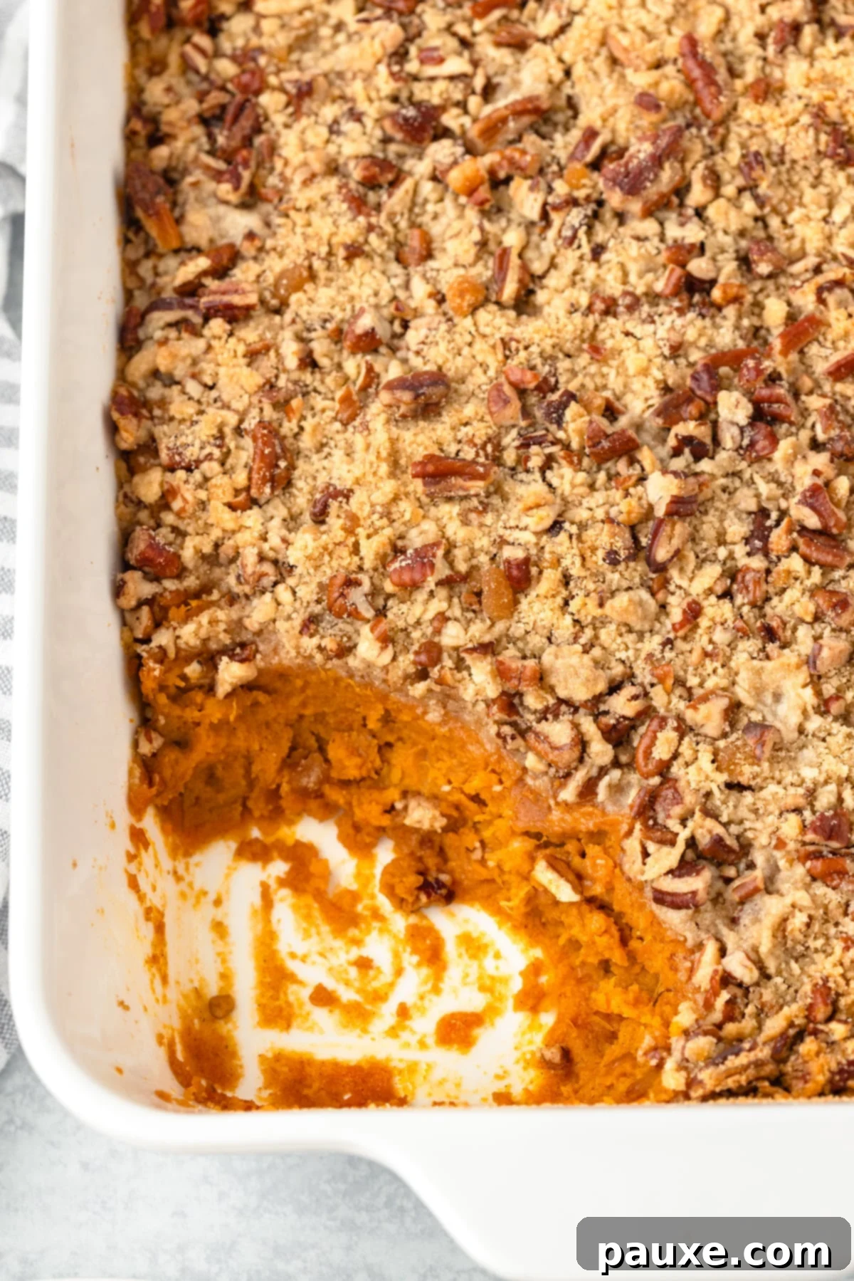 Pecan Streusel Sweet Potato Bake 12 A baking dish filled with sweet potato casserole and topped with pecans.