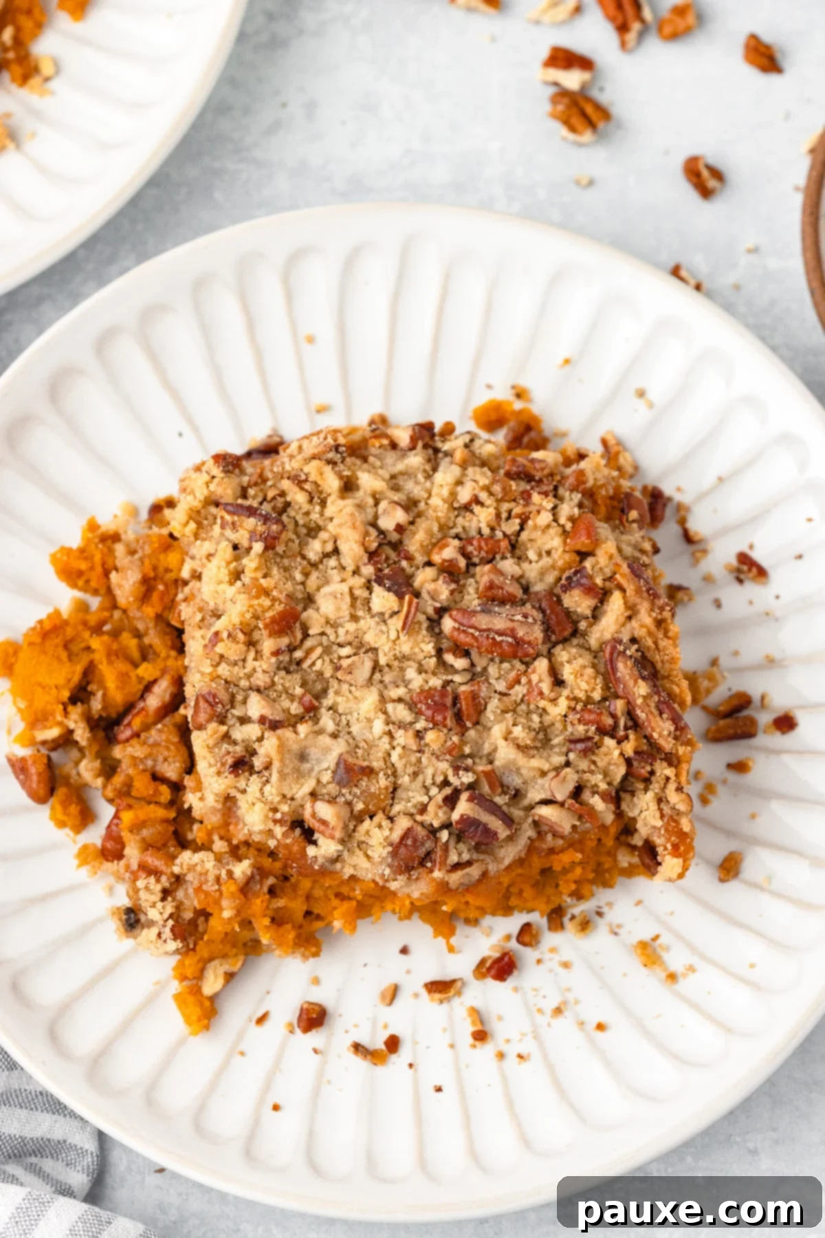 Pecan Streusel Sweet Potato Bake 13 A serving of sweet potato casserole on a white plate.
