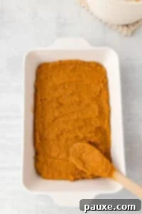 Pecan Streusel Sweet Potato Bake 19 Spreading sweet potato casserole into a baking dish.