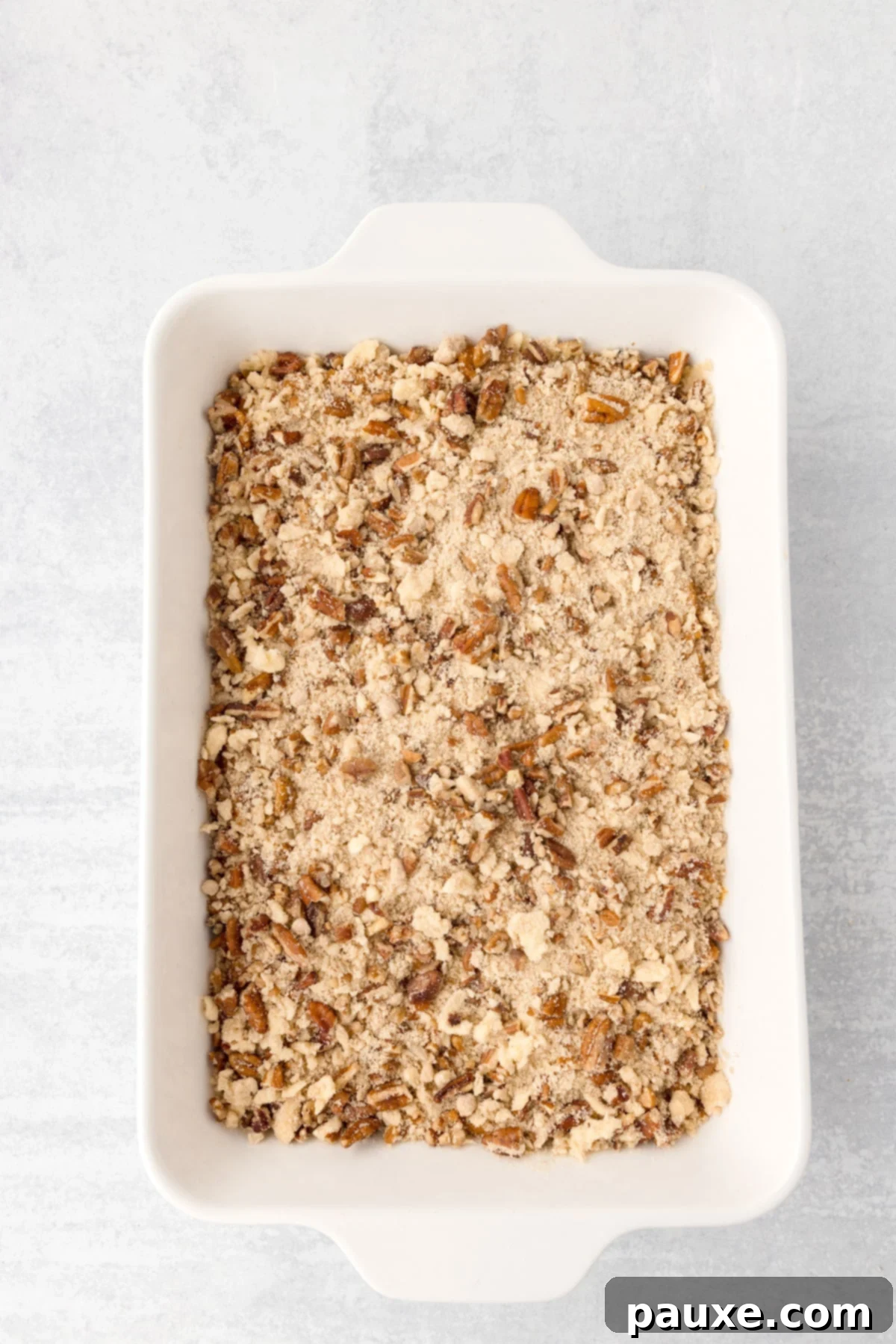 Pecan Streusel Sweet Potato Bake 10 A baking dish filled with an unbaked sweet potato casserole with a pecan crumble.