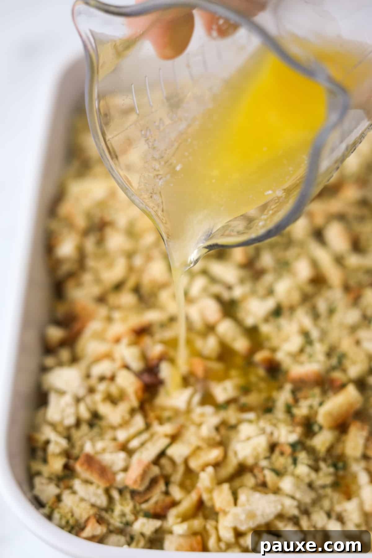 Alpine Chicken Comfort Bake 11 Melted butter being drizzled over the dry stuffing mix topping on the casserole.