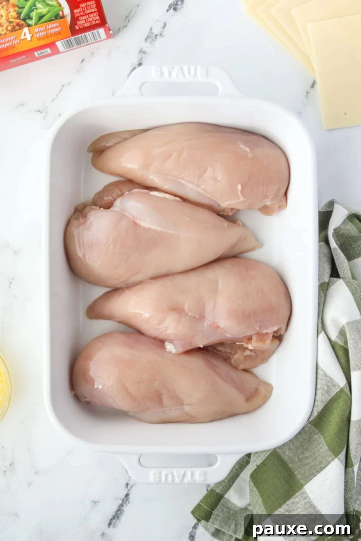 Alpine Chicken Comfort Bake 6 Four raw chicken breasts arranged neatly in a baking dish.