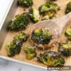 Zesty Ranch Roasted Broccoli 14 A wooden spoon taking a portion of roasted ranch broccoli from a baking sheet.