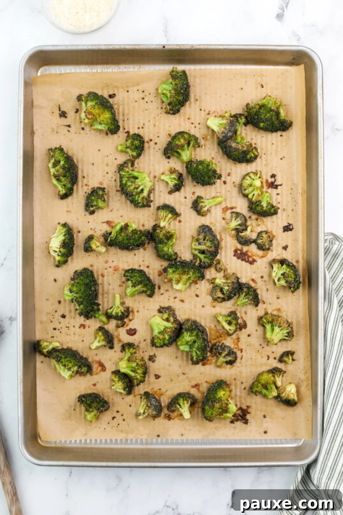 Zesty Ranch Roasted Broccoli 9 Freshly roasted ranch broccoli florets with beautiful browned edges and a tender appearance, spread out on a baking sheet.