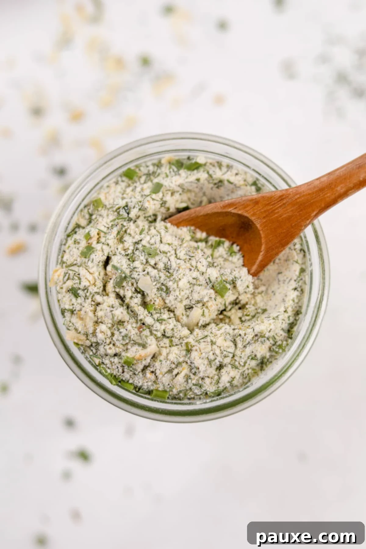 A small glass jar filled with golden-hued homemade ranch seasoning, ready for use.