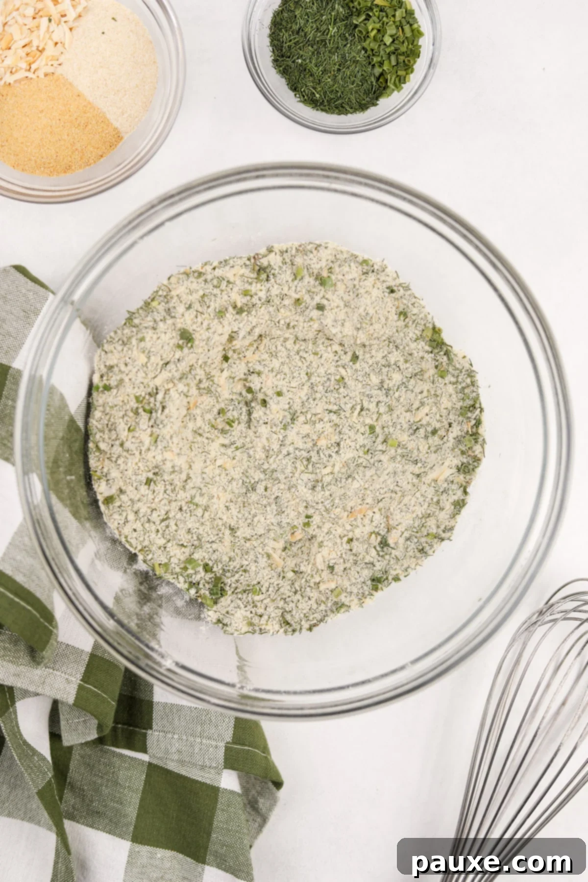 A bowl of freshly prepared homemade ranch seasoning, with a metal whisk resting on the side of the bowl.