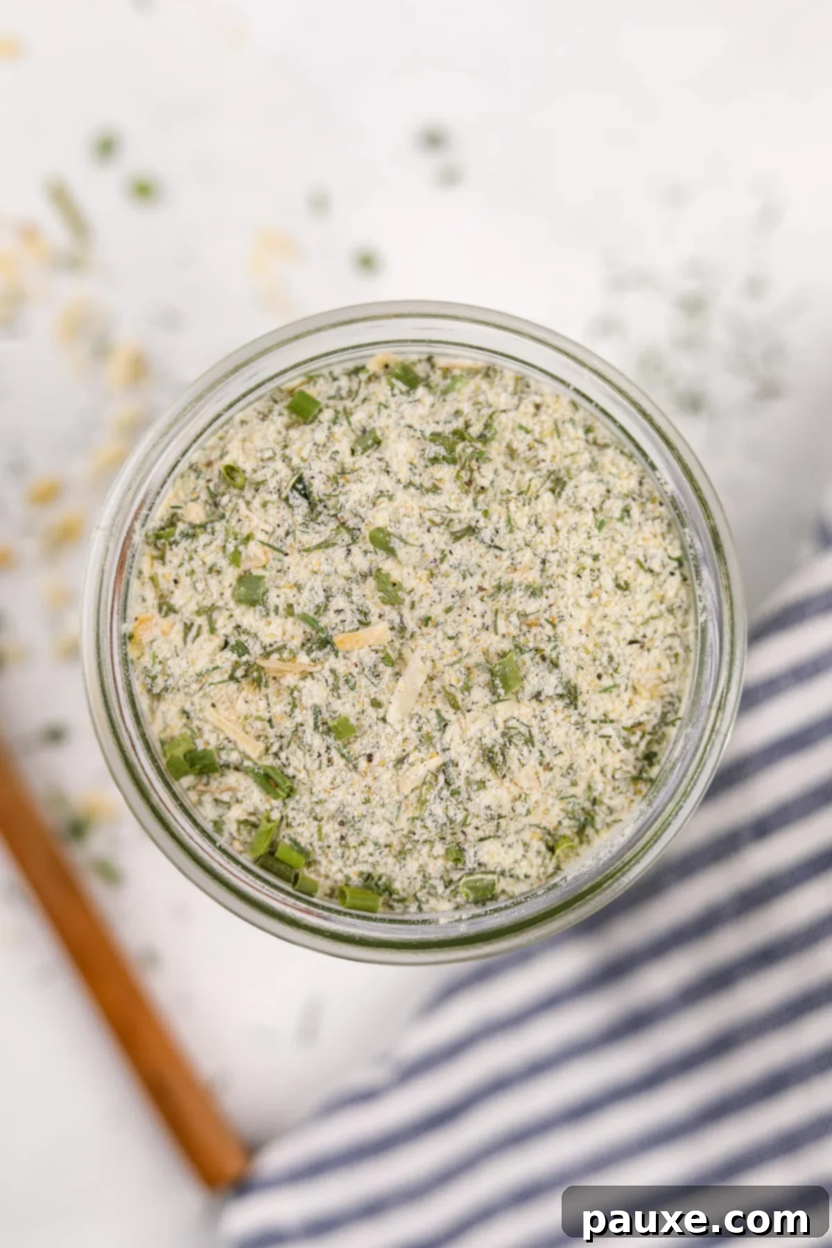 A clear glass mason jar filled with homemade ranch dry mix, sealed with a lid and ready for storage.
