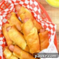 Air Fryer Pigs in a Crispy Blanket 10 A basket of pigs in a blanket in a red basket, ready to serve.